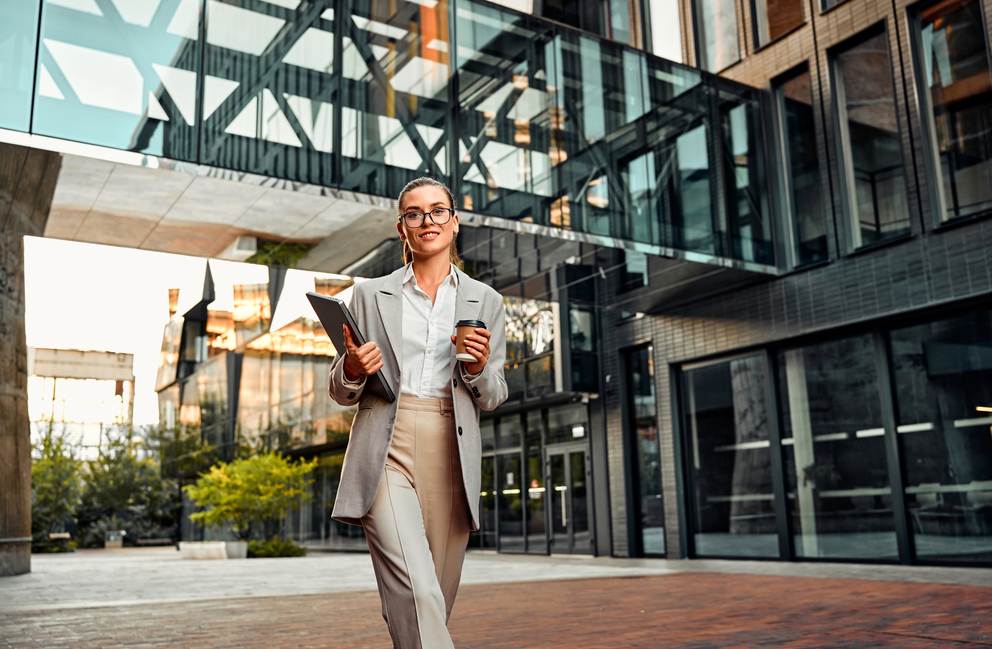 Beautiful successful confident sincere stylish business woman in elegant clothes walking on the stre